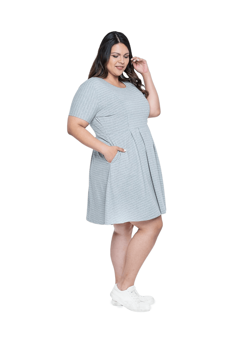 Curvy model facing the side wearing grey with white pin striped, knee length dress, featuring rounded neckline, fitted bodice, pleated A-line skirt and pockets. Kaitlyn available in sizes 6-26