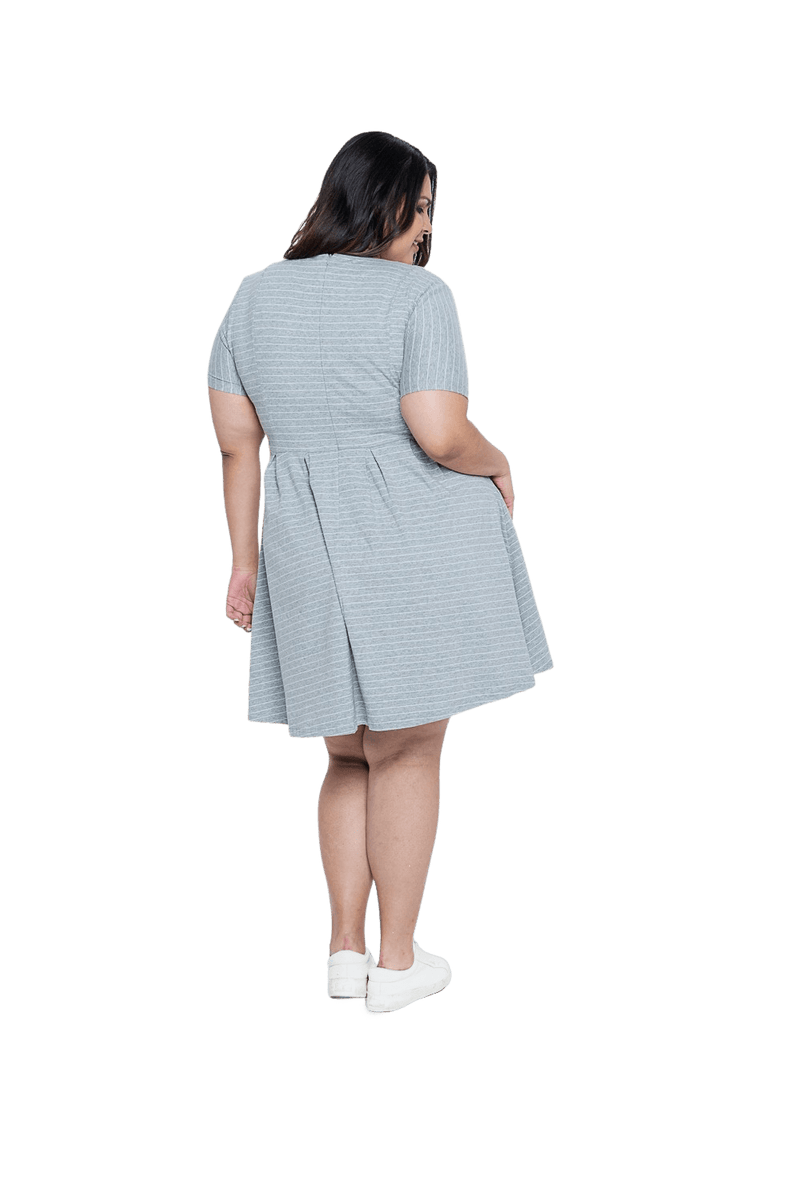Curvy model facing the back wearing grey with white pin striped, knee length dress, featuring rounded neckline, fitted bodice, pleated A-line skirt and pockets. Kaitlyn available in sizes 6-26