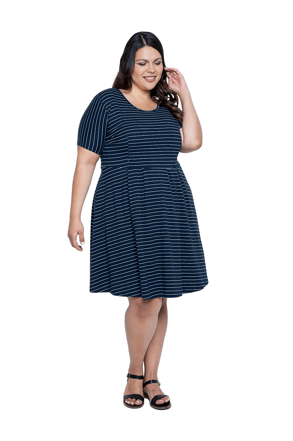 Curvy model facing camera wearing navy with white pin striped, knee length dress, featuring rounded neckline, fitted bodice, pleated A-line skirt and pockets. Kaitlyn available in sizes 6-26