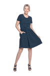Petite model facing camera wearing navy with white pin striped, knee length dress, featuring rounded neckline, fitted bodice, pleated A-line skirt and pockets. Kaitlyn available in sizes 6-26