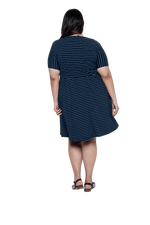 Curvy model facing the back wearing navy with white pin striped, knee length dress, featuring rounded neckline, fitted bodice, pleated A-line skirt and pockets. Kaitlyn available in sizes 6-26