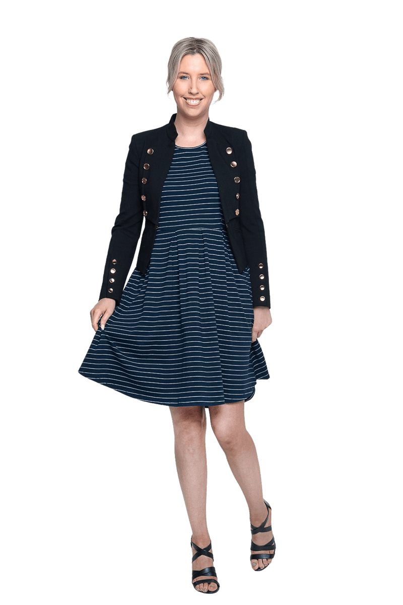 Petite model facing the camera wearing navy with white pin striped, knee length dress and black blazer, featuring rounded neckline, fitted bodice, pleated A-line skirt and pockets. Kaitlyn available in sizes 6-26