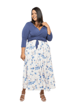 Curvy model facing camera wearing maxi dress with blue mid sleeved crossover top attached to white skirt with blue and tan watercolour accents. Mai available in sizes 6-26