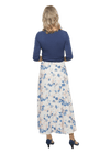 Petite model facing the back wearing maxi dress with blue mid sleeved crossover top attached to white skirt with blue and tan watercolour accents. Mai available in sizes 6-26