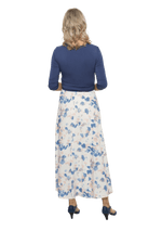 Petite model facing the back wearing maxi dress with blue mid sleeved crossover top attached to white skirt with blue and tan watercolour accents. Mai available in sizes 6-26