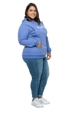 Petite model facing side wearing cornflour blue hoodie, featuring front pocket, and white Mama print across the chest. Mama hoodie available in sizes 6-26
