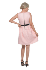 Petite model facing the back wearing pink cocktail dress, featuring a boat neckline, back zip and a feature black sash across the waist. Marie available in sizes 6-18