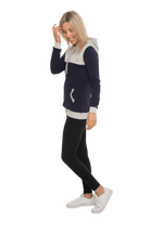Petite model facing the side wearing navy hoodie with grey panel over chest, shoulders, and top of back, featuring front pocket, and grey highlights at pocket openings and sleeve cuffs. Olivia hoodie available in sizes 6-26