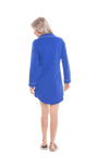 Petite model facing the back wearing royal blue button up, mid thigh length pyjama shirt, featuring fold over collar, scooped hemline, and white piping. Parker available in sizes 6-18