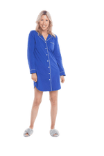 Petite model facing camera wearing royal blue button up, mid thigh length pyjama shirt, featuring fold over collar, scooped hemline, and white piping. Parker available in sizes 6-18