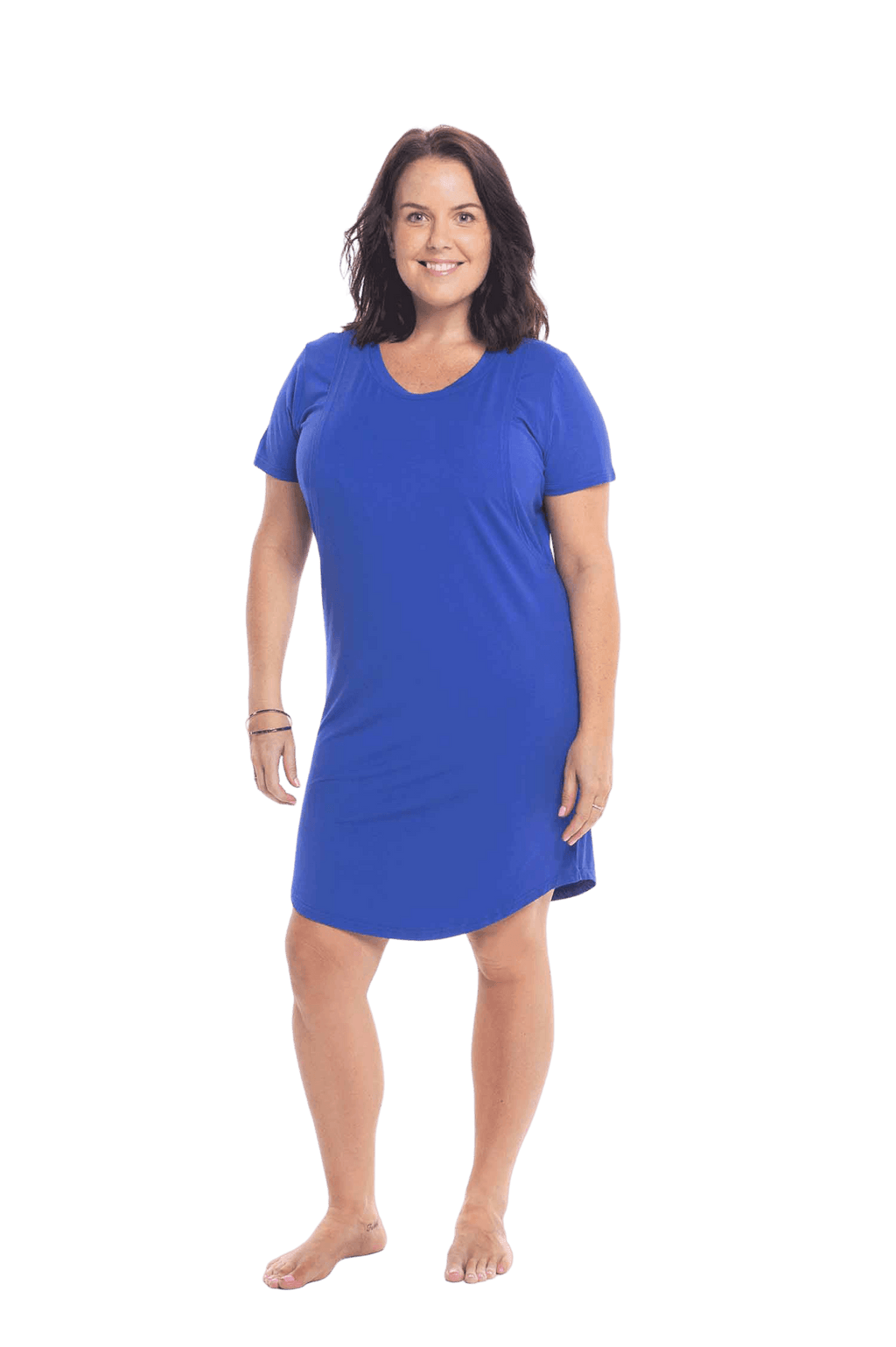 Brunette model facing camera wearing royal blue mid thigh length nightie, featuring rounded neckline, scooped hemline with short sleeves. Penny available in sizes 6-18