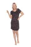 Petite model facing camera wearing black with small red rose patterned mid thigh length nightie, featuring rounded neckline, scooped hemline with short sleeves. Penny available in sizes 6-18