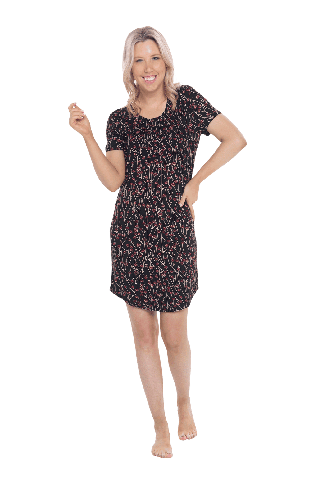 Petite model facing camera wearing black with small red rose patterned mid thigh length nightie, featuring rounded neckline, scooped hemline with short sleeves. Penny available in sizes 6-18