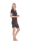 Petite model facing the side wearing black with small red rose patterned mid thigh length nightie, featuring rounded neckline, scooped hemline with short sleeves. Penny available in sizes 6-18