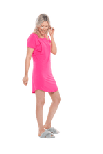 Blonde model facing the side wearing hot pink mid thigh length nightie, featuring rounded neckline, scooped hemline with short sleeves. Penny available in sizes 6-18