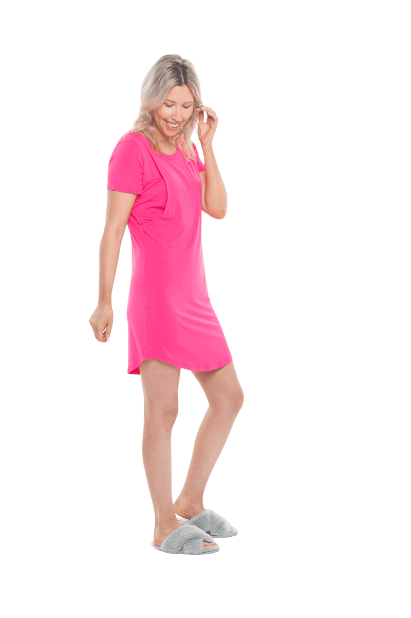 Blonde model facing the side wearing hot pink mid thigh length nightie, featuring rounded neckline, scooped hemline with short sleeves. Penny available in sizes 6-18