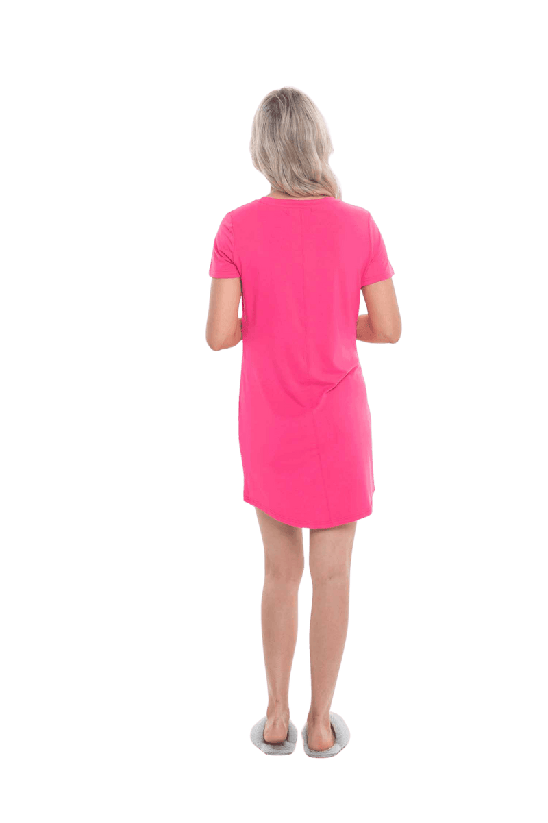 Blonde model facing the back wearing hot pink mid thigh length nightie, featuring rounded neckline, scooped hemline with short sleeves. Penny available in sizes 6-18