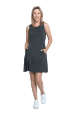 Petite model facing camera wearing charcoal grey mid thigh length dress, featuring rounded neckline, pockets and a waist sash tied at the back. Peyton available in sizes 6-26