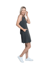 Petite model facing the side wearing charcoal grey mid thigh length dress, featuring rounded neckline, pockets and a waist sash tied at the back. Peyton available in sizes 6-26