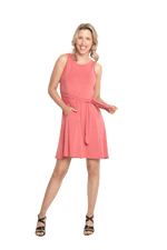 Petite model facing camera wearing dusty pink mid thigh length dress, featuring rounded neckline, pockets and a waist sash tied at the front. Peyton available in sizes 6-26