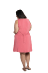 Curvy model facing the back wearing dusty pink mid thigh length dress, featuring rounded neckline, pockets and a waist sash tied at the back. Peyton available in sizes 6-26