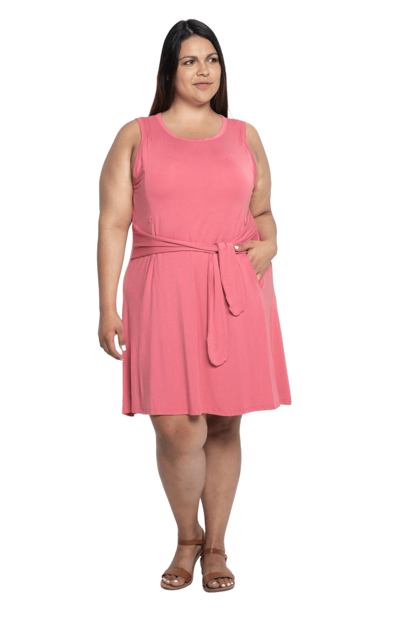 Curvy model facing camera wearing dusty pink mid thigh length dress, featuring rounded neckline, pockets and a waist sash tied at the front. Peyton available in sizes 6-26