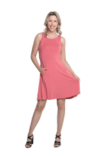Petite model facing the camera wearing dusty pink mid thigh length dress, featuring rounded neckline, pockets and a waist sash tied at the back. Peyton available in sizes 6-26