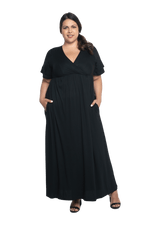 Curvy model facing camera wearing black maxi dress, featuring crossover V-neck, double layer detailed sleeves, pockets and a beautiful Grecian flowing silhouette. Phoebe available in sizes 6-26