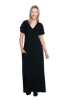 Petite model facing camera wearing black maxi dress, featuring crossover V-neck, double layer detailed sleeves, pockets and a beautiful Grecian flowing silhouette. Phoebe available in sizes 6-26
