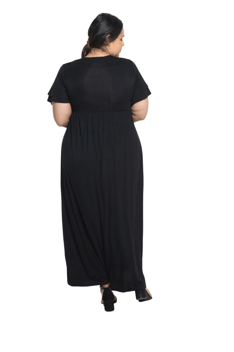 Curvy model facing the back wearing black maxi dress, featuring crossover V-neck, double layer detailed sleeves, pockets and a beautiful Grecian flowing silhouette. Phoebe available in sizes 6-26