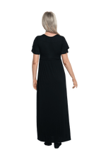 Petite model facing the back wearing black maxi dress, featuring crossover V-neck, double layer detailed sleeves, pockets and a beautiful Grecian flowing silhouette. Phoebe available in sizes 6-26