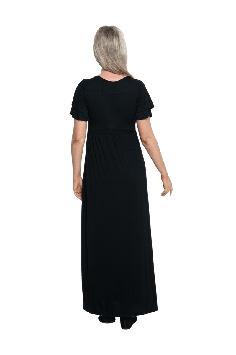 Petite model facing the back wearing black maxi dress, featuring crossover V-neck, double layer detailed sleeves, pockets and a beautiful Grecian flowing silhouette. Phoebe available in sizes 6-26