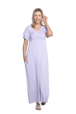 Petite model facing camera wearing lilac maxi dress, featuring crossover V-neck, double layer detailed sleeves, pockets and a beautiful Grecian flowing silhouette. Phoebe available in sizes 6-26