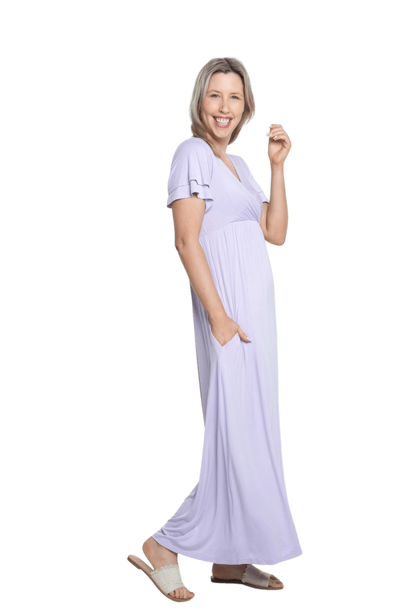 Petite model facing the side wearing lilac maxi dress, featuring crossover V-neck, double layer detailed sleeves, pockets and a beautiful Grecian flowing silhouette. Phoebe available in sizes 6-26