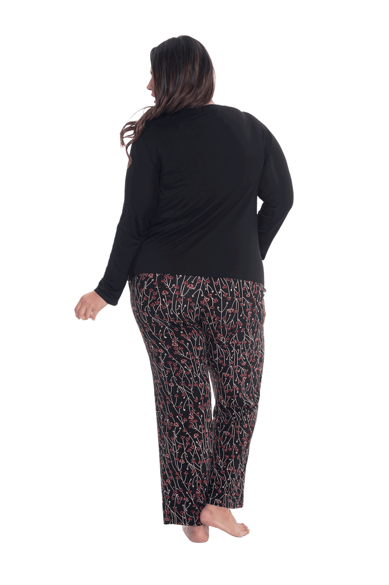 Curvy model facing the back wearing long sleeved pyjamas with pants. Top is black with contrast breast pocket matching pants. Pants are black with small red rose pattern, featuring pockets, and elasticated waist with pull tie. Piper available in sizes 6-26