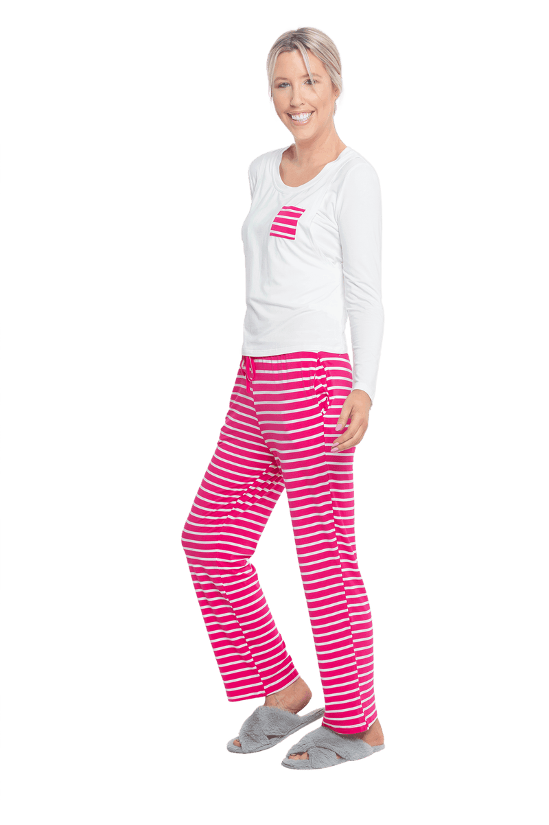 Petite model facing the side wearing long sleeved pyjamas with pants. Top is white with contrast breast pocket matching pants. Pants are hot pink and white stripe, featuring pockets, and elasticated waist with pull tie. Piper available in sizes 6-18