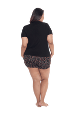 Curvy model facing the back wearing short sleeved pyjamas with shorts. Top is black with contrast breast pocket matching shorts. Shorts are black with small red rose pattern, featuring pockets, and elasticated waist with pull tie. Poppy available in sizes 6-26