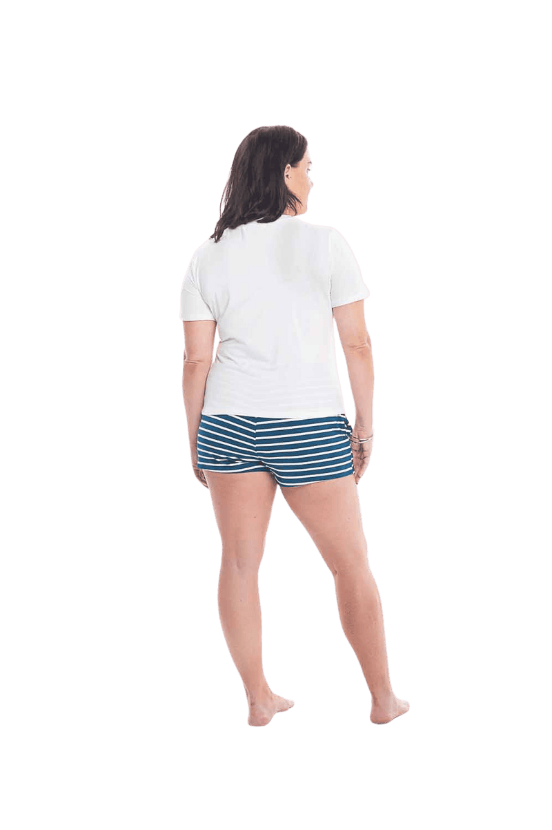 Brunette model facing the back wearing long sleeved pyjamas with pants. Top is white with contrast breast pocket matching pants. Pants are teal and white stripe, featuring pockets, and elasticated waist with pull tie. Piper available in sizes 6-18
