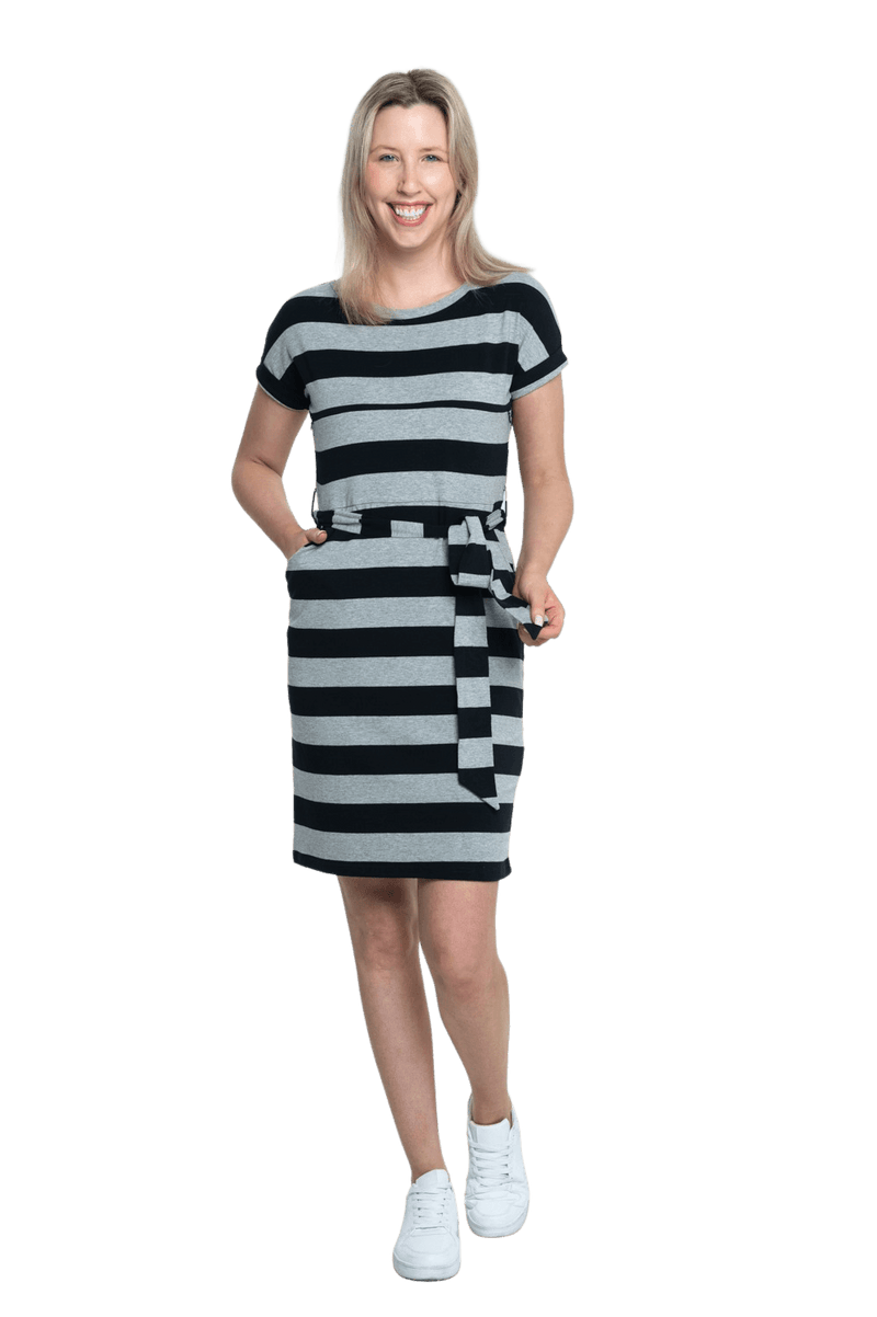 Petite model facing camera wearing charcoal grey and black striped t-shirt dress, featuring rounded neckline, pockets, belt feature, and capped sleeves. Quinn available in sizes 6-26