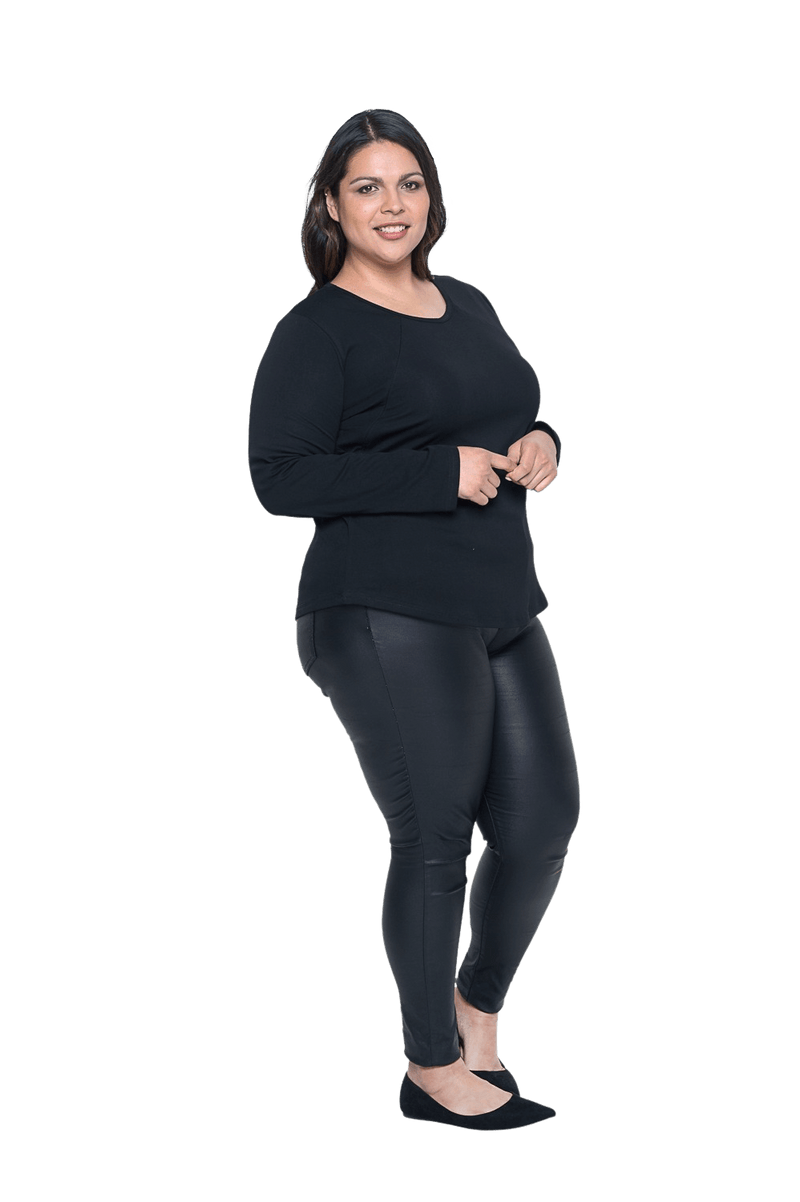 Curvy model facing the side wearing black long sleeved top, featuring soft V-neck and a scooped hem. Reese available in sizes 6-26