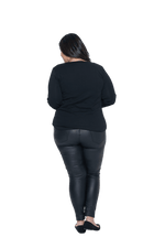 Curvy model facing the back wearing black long sleeved top, featuring soft V-neck and a scooped hem. Reese available in sizes 6-26