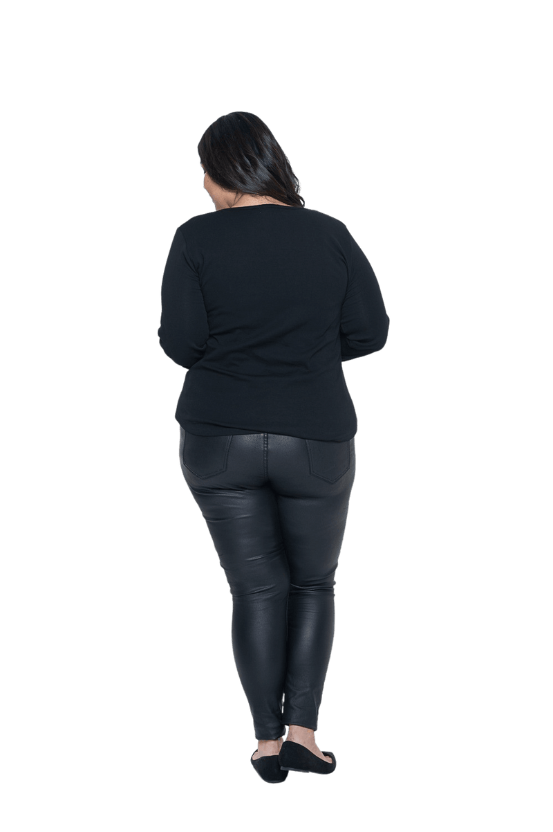 Curvy model facing the back wearing black long sleeved top, featuring soft V-neck and a scooped hem. Reese available in sizes 6-26