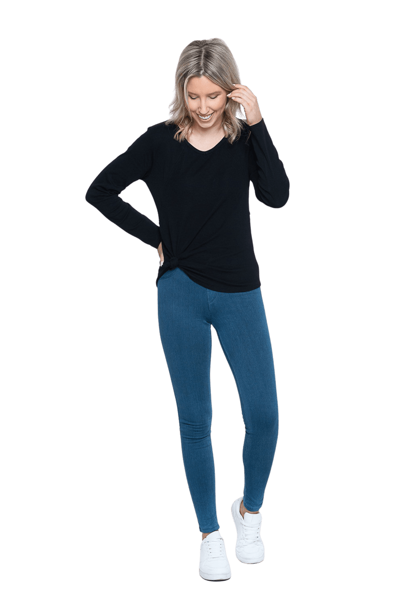 Petite model facing the camera wearing black long sleeved top tied at the hip, featuring soft V-neck and a scooped hem. Reese available in sizes 6-26