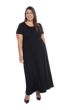 Curvy model facing camera wearing black maxi dress, featuring  rounded neckline, and a gently fitted bodice, gathering above the waist. Riley available in sizes 6-26