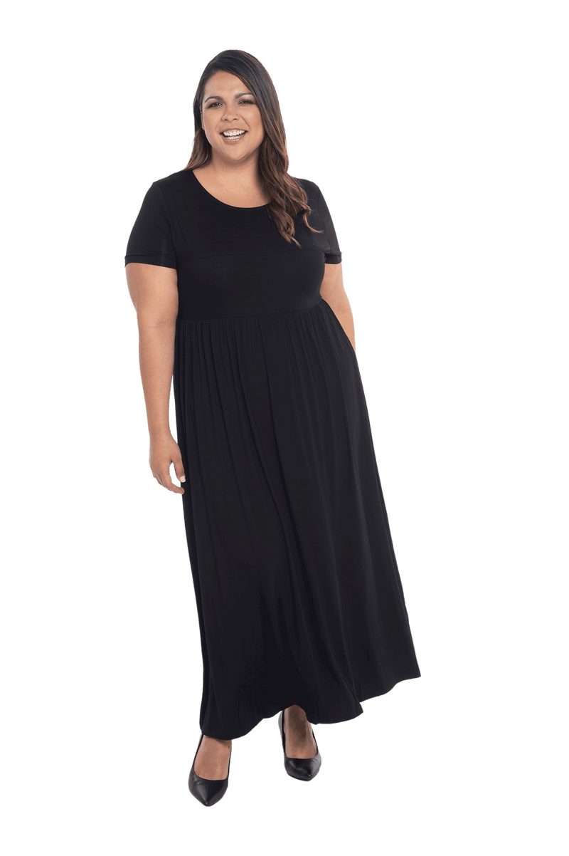 Curvy model facing camera wearing black maxi dress, featuring  rounded neckline, and a gently fitted bodice, gathering above the waist. Riley available in sizes 6-26