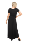 Petite model facing the back wearing black maxi dress, featuring  rounded neckline, and a gently fitted bodice, gathering above the waist. Riley available in sizes 6-26