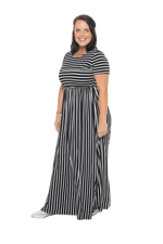 Brunette model facing the side wearing black and white striped maxi dress, featuring rounded neckline, and a gently fitted bodice, gathering above the waist. Riley available in sizes 6-18