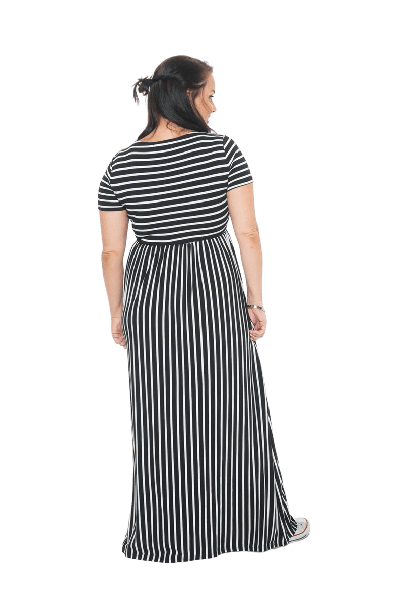 Brunette model facing the back wearing black and white striped maxi dress, featuring rounded neckline, and a gently fitted bodice, gathering above the waist. Riley available in sizes 6-18