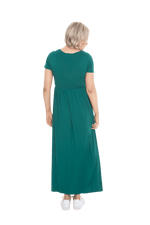 Petite model facing the back wearing bottle green maxi dress, featuring  rounded neckline, and a gently fitted bodice, gathering above the waist. Riley available in sizes 6-26