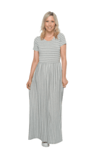 Petite model facing the camera wearing light grey and white striped maxi dress, featuring rounded neckline, and a gently fitted bodice, gathering above the waist. Riley available in sizes 6-18